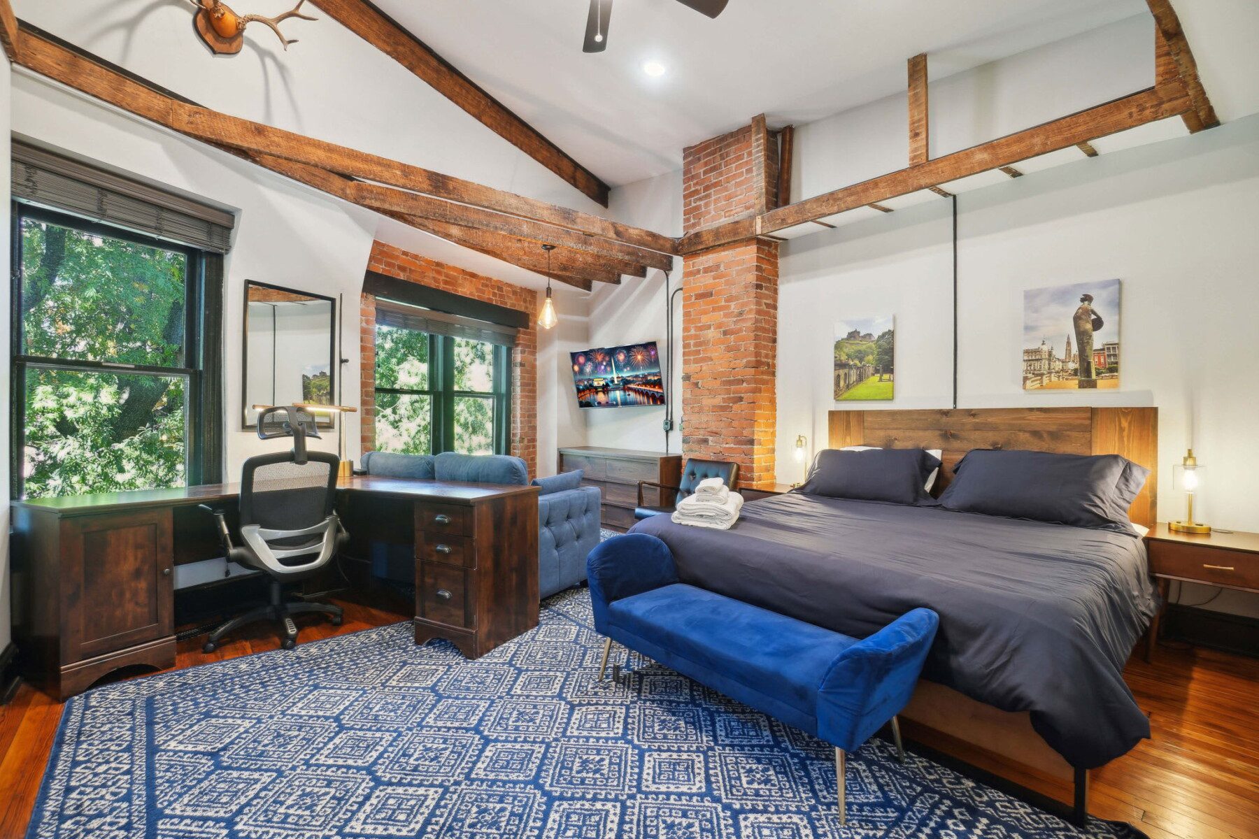 Bedroom interior in the 8BR DC Mansion with exposed brick and wood beams